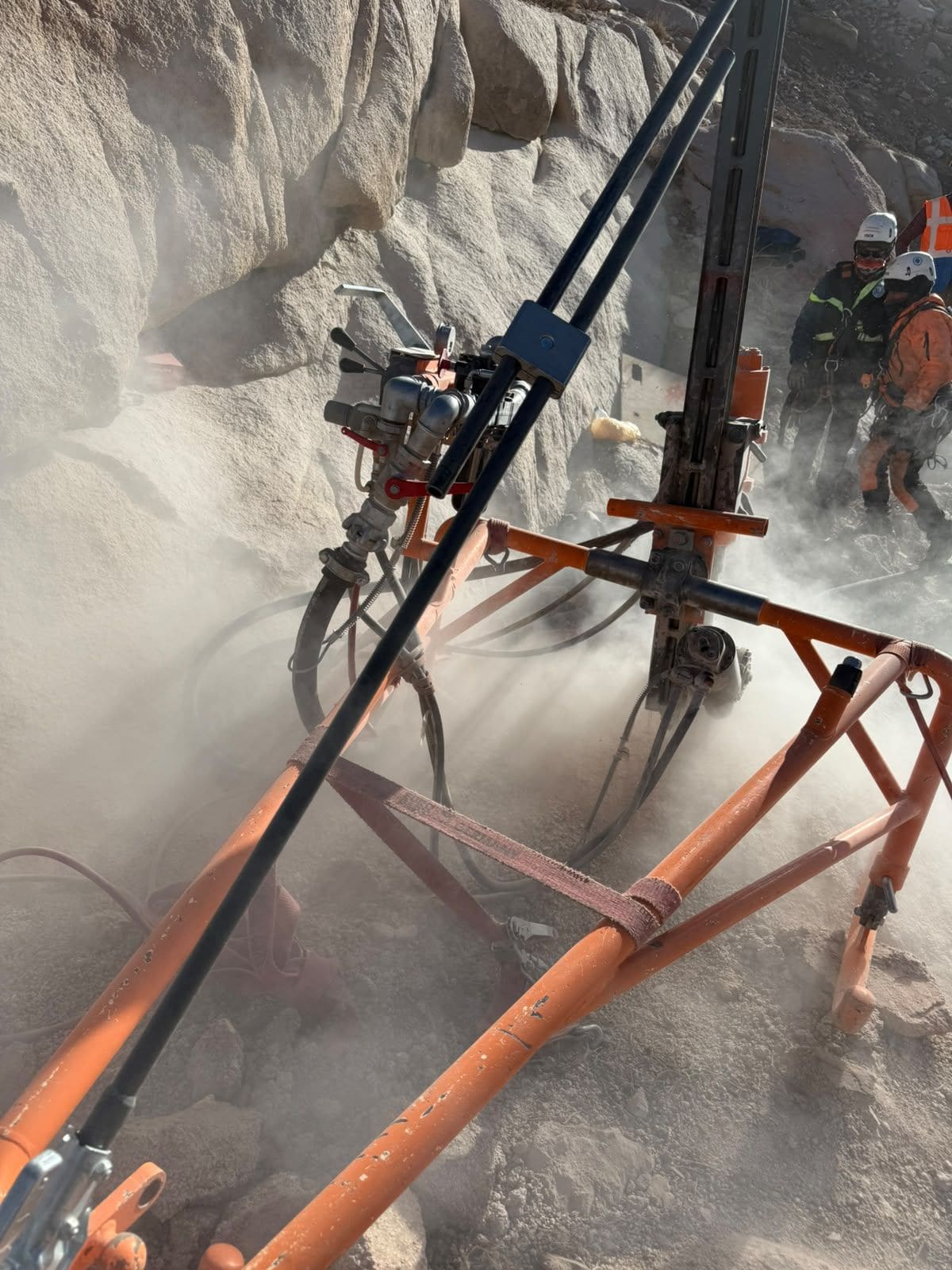 Drilling crew operating a rig on a rock slope