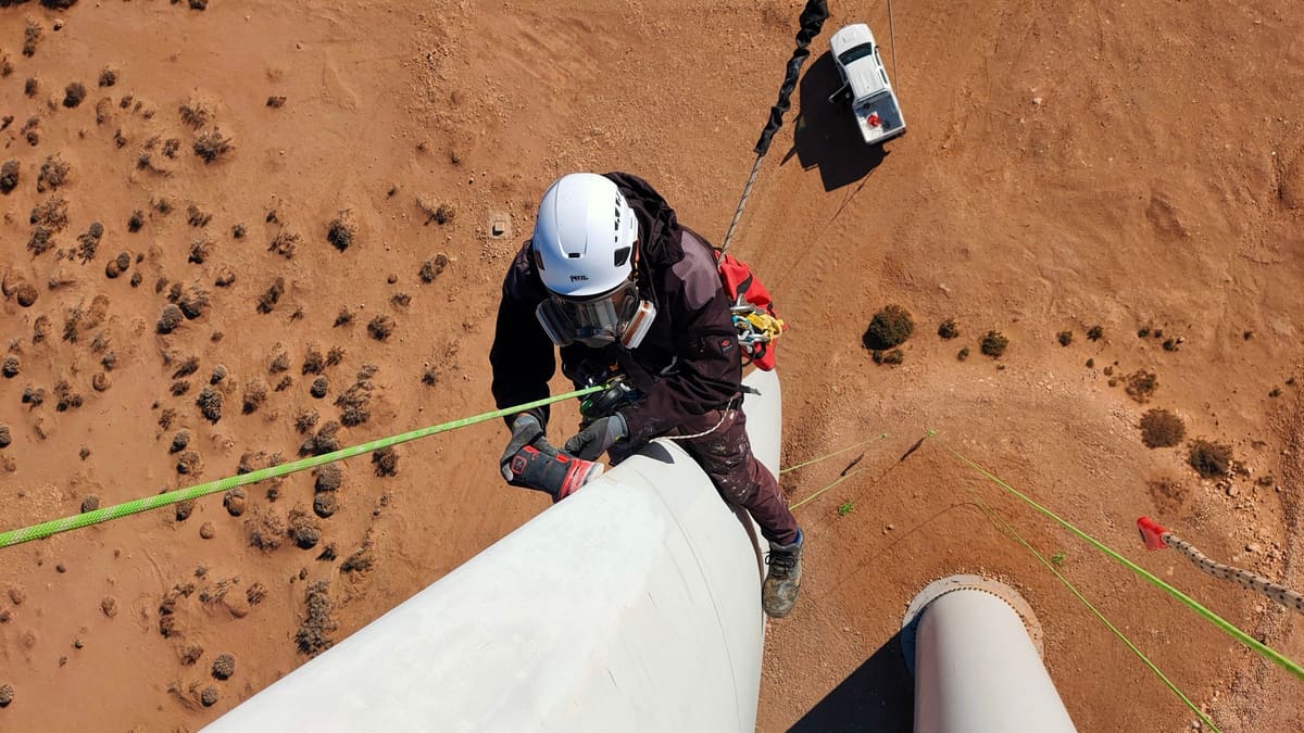 Rope access technician preparing a blade leading edge for repair