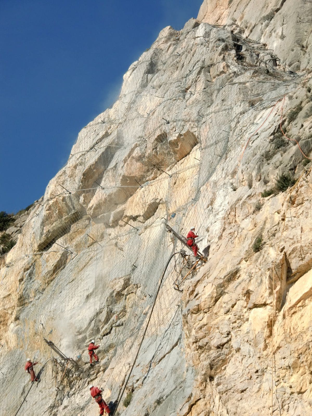 Rope access team scaling a rock wall