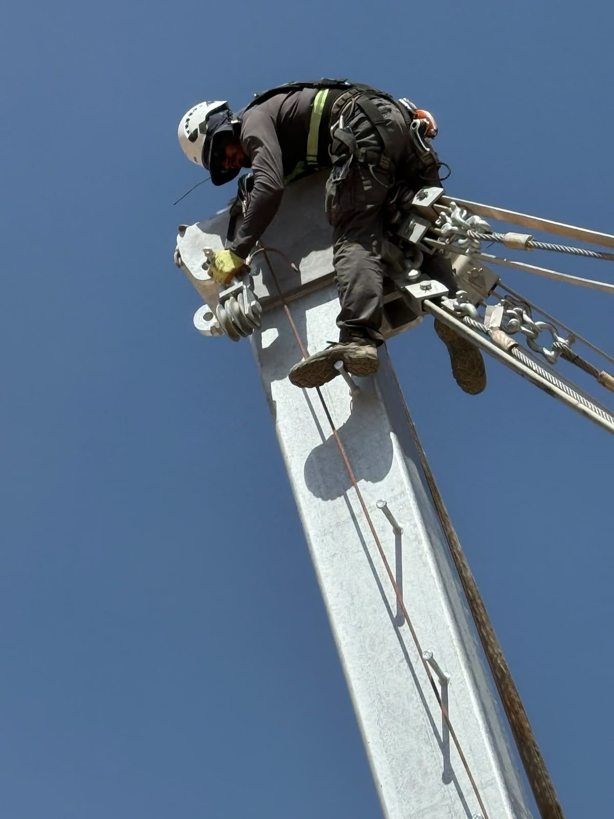 Technician working on top of a rockfall barrier post